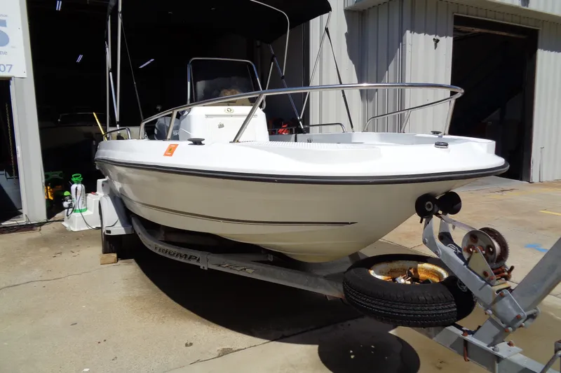 Slide: The Image of 2004 Triumph 190 Bay boat on trailer, parked outside a garage. - 3