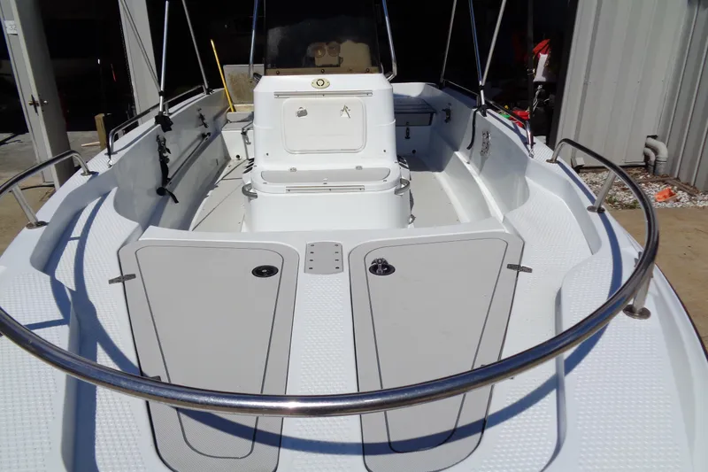 Slide: The Image of 2004 Triumph 190 Bay boat interior with white seating and storage compartments. - 4