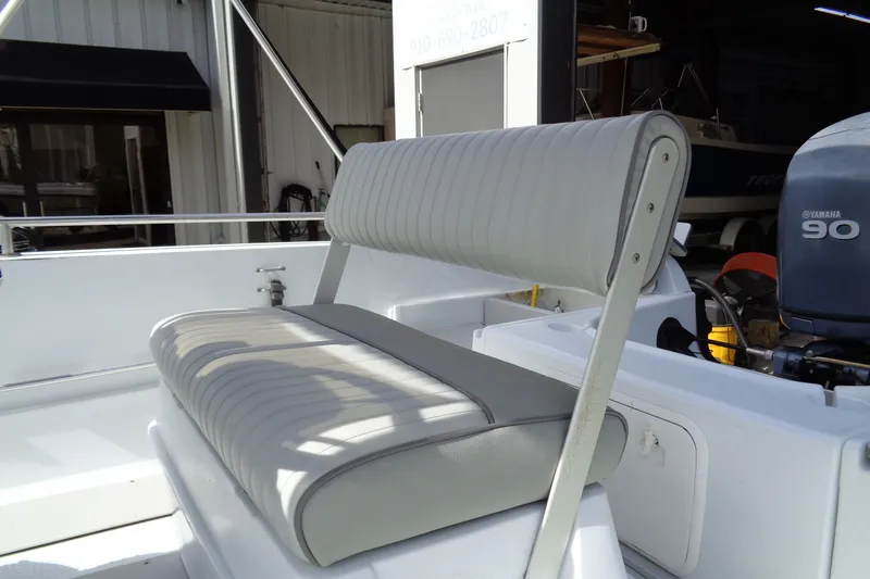 Slide: The Image of 2004 Triumph 190 Bay boat seat with Yamaha 90 engine in a garage setting. - 10