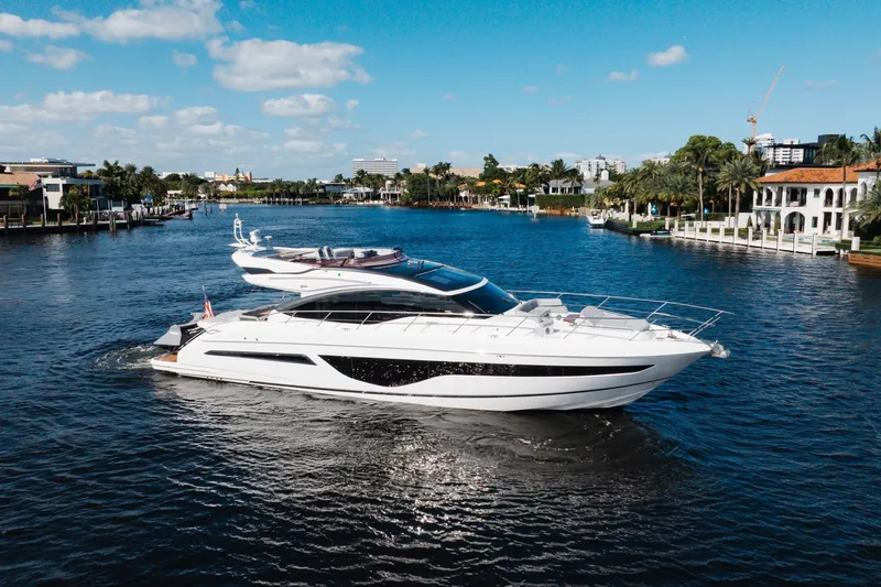 The Image of Luxurious 2021 Princess S66 yacht cruising on a scenic waterway under a clear blue sky. - 0