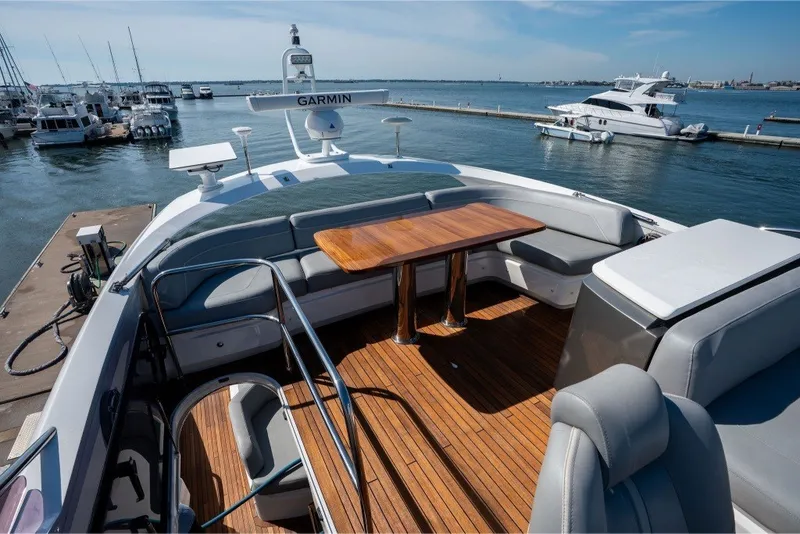 Slide: The Image of Luxurious 2021 Princess S66 yacht deck with seating and wooden table, docked at marina. - 35