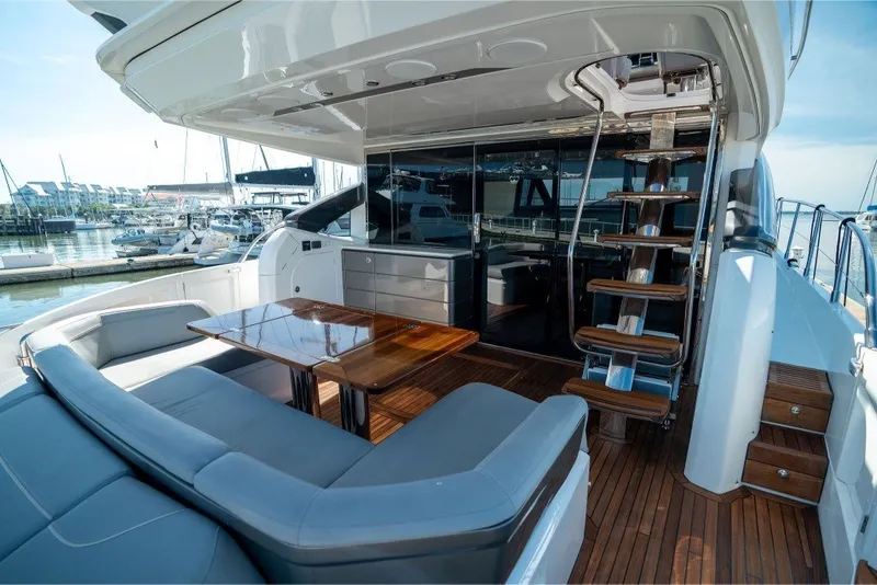 Slide: The Image of Luxurious 2021 Princess S66 yacht deck with seating, table, and marina view. - 1