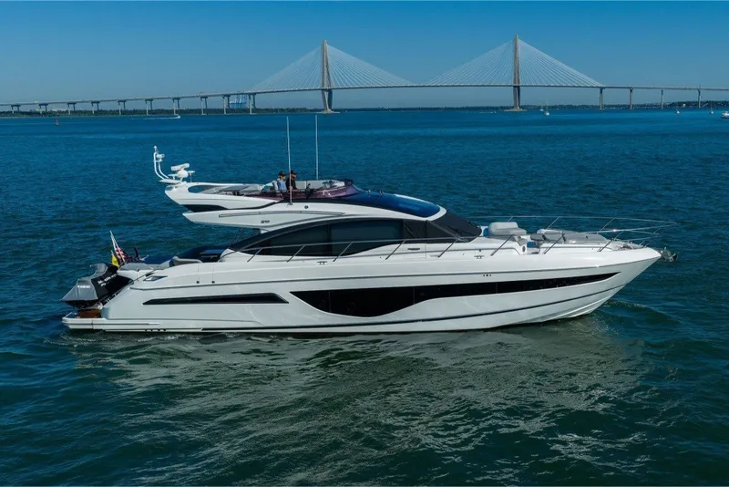 Slide: The Image of Luxurious 2021 Princess S66 yacht cruising on blue waters with a scenic bridge backdrop. - 9
