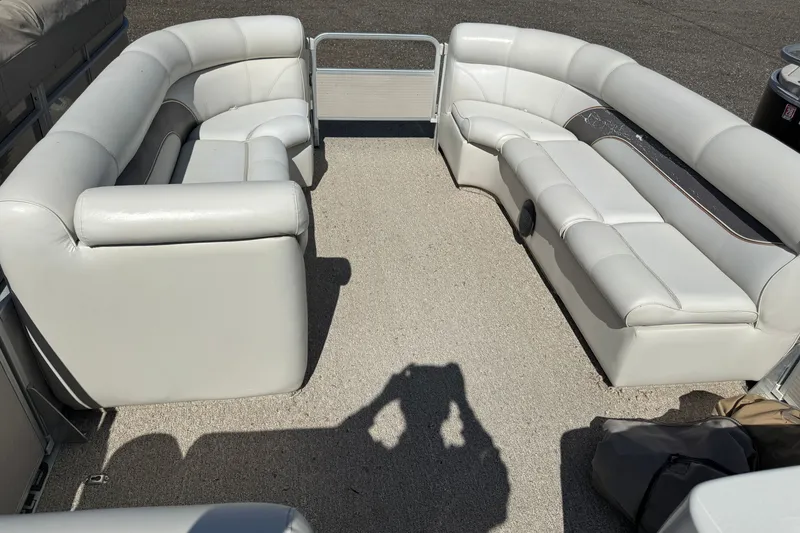 Slide: The Image of 2003 Premier 24 pontoon boat interior with white seating and carpeted floor. - 11