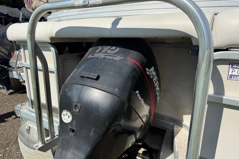 Slide: The Image of 2003 Premier 24 boat with Mercury FourStroke outboard motor, docked in sunlight. - 3