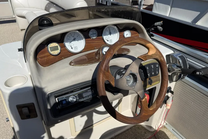 Slide: The Image of Steering console of a 2003 Premier 24 boat with wood accents and gauges. - 9