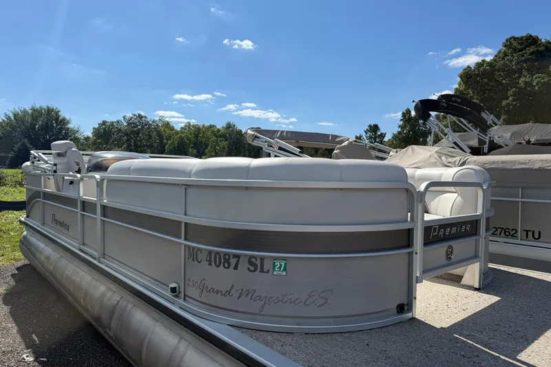 Slide: The Image of 2003 Premier 24 pontoon boat with white seating, docked outdoors under a clear sky. - 1