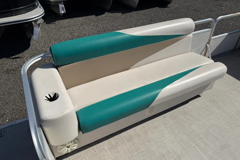 Slide: The Image of 1997 Sweetwater 24es boat seat with teal and beige upholstery, featuring a built-in cup holder. - 7