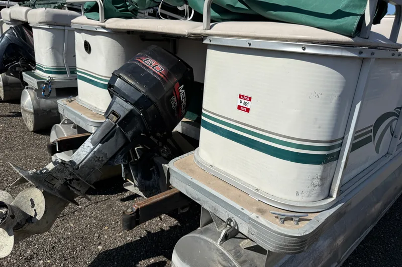 Slide: The Image of 1997 Sweetwater 24es pontoon boat with Mercury 60 outboard motor, docked on gravel. - 10