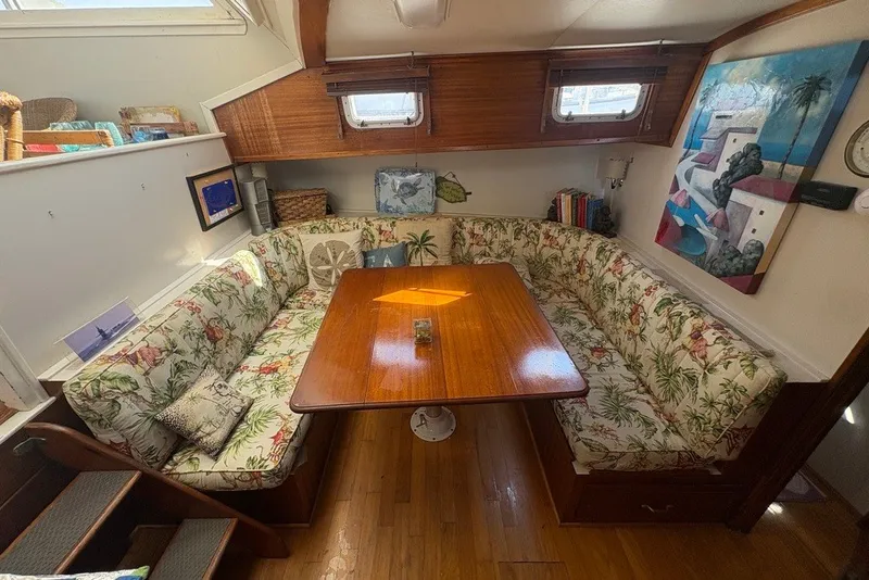 Slide: The Image of Cozy dining area in a 1975 Gulfstar 43 Trawler with floral upholstery and wooden table. - 18