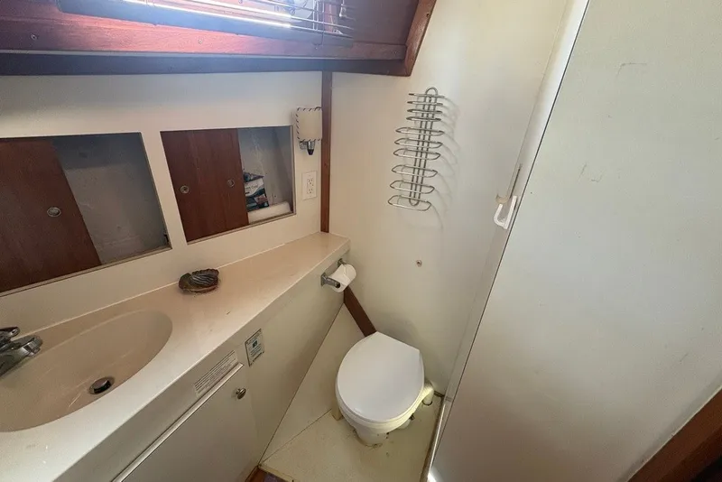 Slide: The Image of 1975 Gulfstar 43 Trawler bathroom with sink, toilet, and storage cabinets. - 30