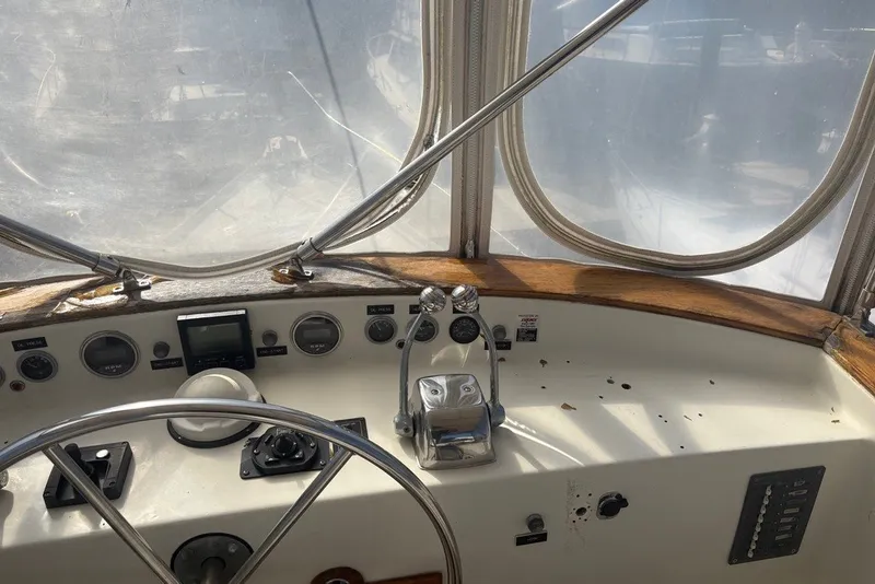Slide: The Image of 1975 Gulfstar 43 Trawler helm with steering wheel, gauges, and throttle controls. - 70