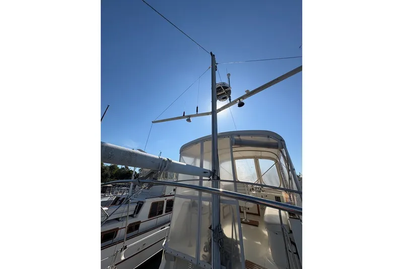 Slide: The Image of 1975 Gulfstar 43 Trawler with sunlit deck and mast against clear blue sky. - 80