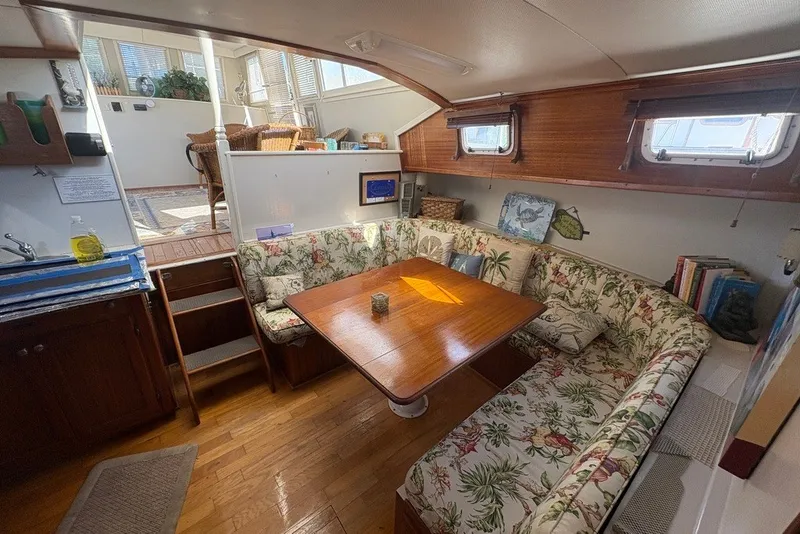 Slide: The Image of Interior of a 1975 Gulfstar 43 Trawler with floral seating and wooden table. - 19