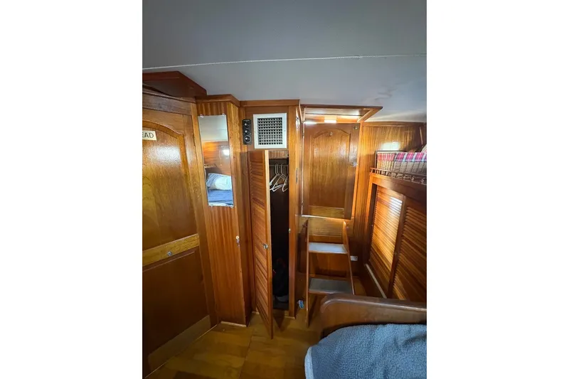 Slide: The Image of Interior of 1975 Gulfstar 43 Trawler with wooden cabinetry and cozy sleeping area. - 59