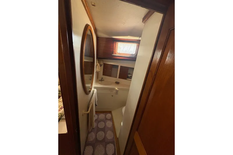 Slide: The Image of Bathroom interior of a 1975 Gulfstar 43 Trawler with wooden accents and oval mirror. - 29