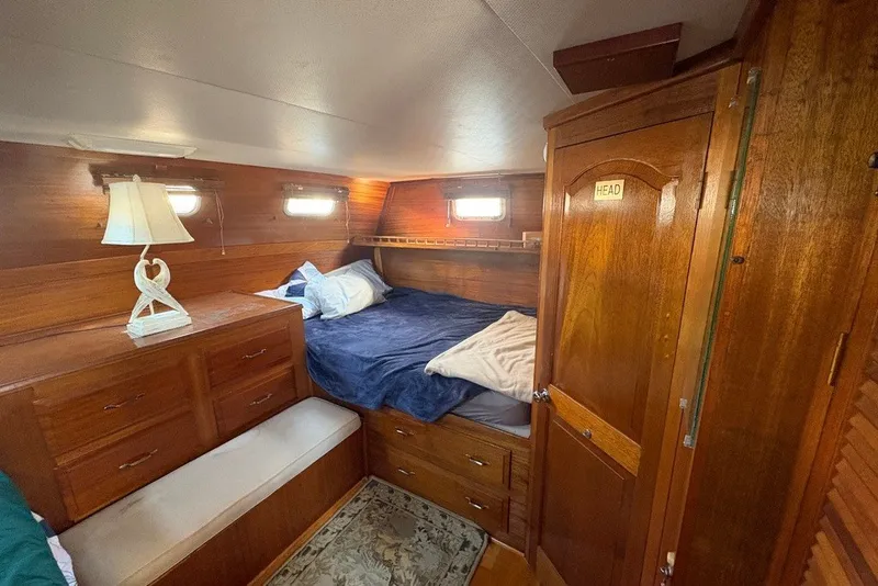 Slide: The Image of Cozy cabin interior of 1975 Gulfstar 43 Trawler with wooden furnishings and soft lighting. - 51