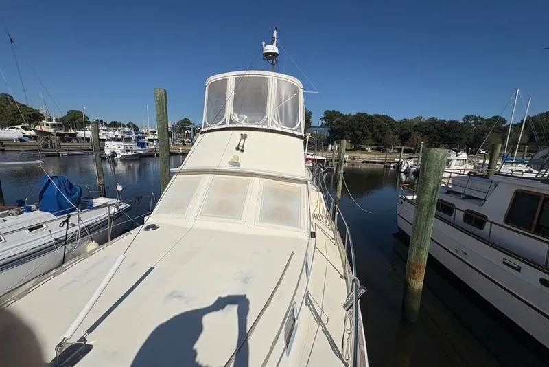 Slide: The Image of 1975 Gulfstar 43 Trawler docked at marina under clear blue sky. - 91