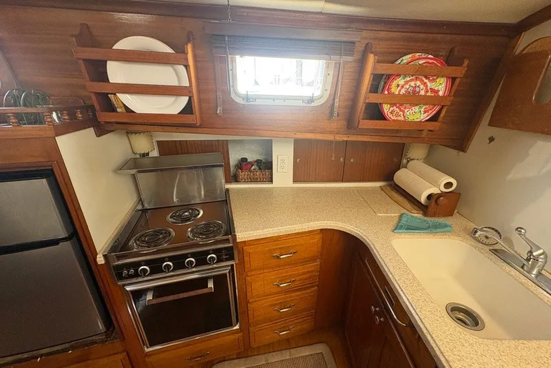 Slide: The Image of 1975 Gulfstar 43 Trawler kitchen with stove, sink, and wooden cabinetry. - 42