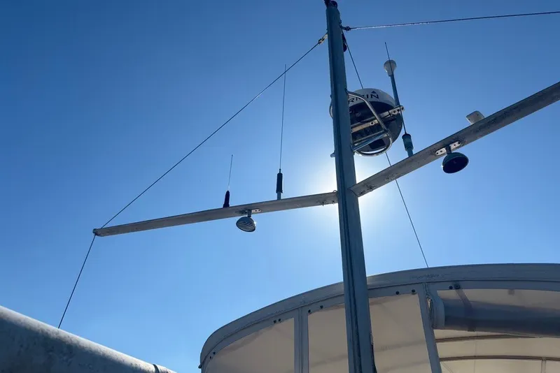 Slide: The Image of 1975 Gulfstar 43 Trawler mast against clear blue sky, featuring radar and antennas. - 79