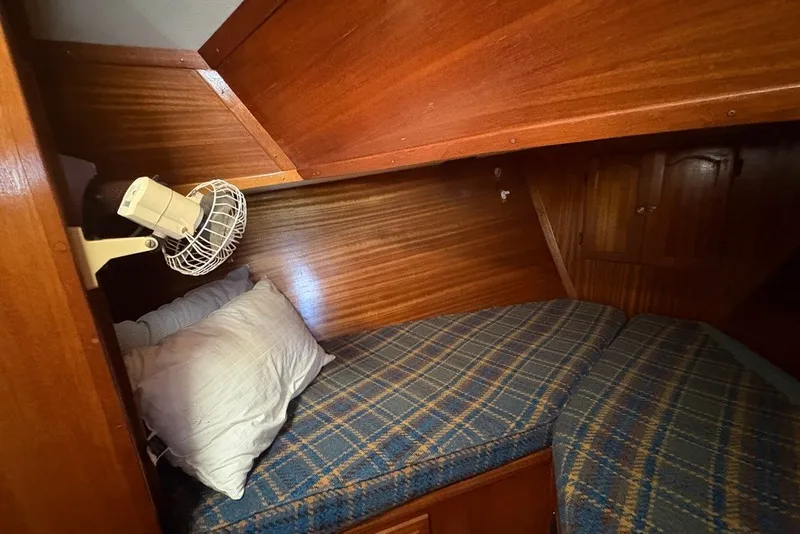 Slide: The Image of Cozy cabin interior of 1975 Gulfstar 43 Trawler with wooden paneling and plaid bedding. - 31