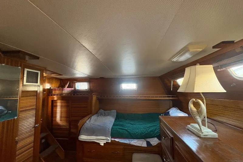 Slide: The Image of Cozy cabin interior of 1975 Gulfstar 43 Trawler with wooden furnishings and a bed. - 62