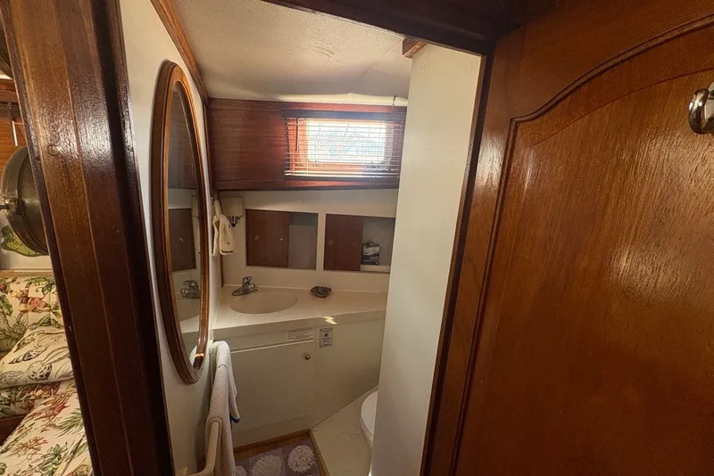 Slide: The Image of Bathroom interior of a 1975 Gulfstar 43 Trawler with wooden accents and oval mirror. - 28