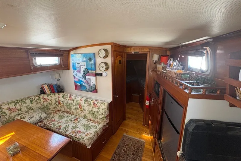 Slide: The Image of Interior of 1975 Gulfstar 43 Trawler with cozy seating, artwork, and wooden accents. - 25