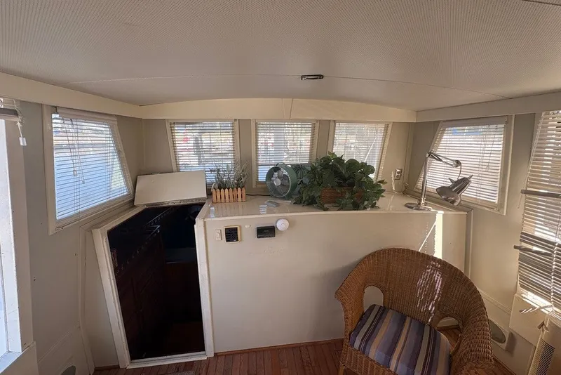 Slide: The Image of Interior of 1975 Gulfstar 43 Trawler with wicker chair, plants, and nautical decor. - 47