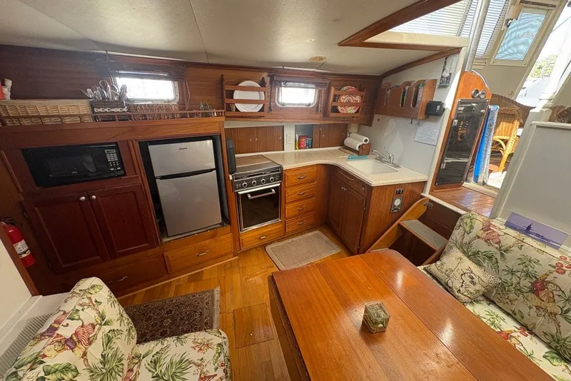 Slide: The Image of 1975 Gulfstar 43 Trawler interior with kitchen, dining area, and wooden cabinetry. - 20