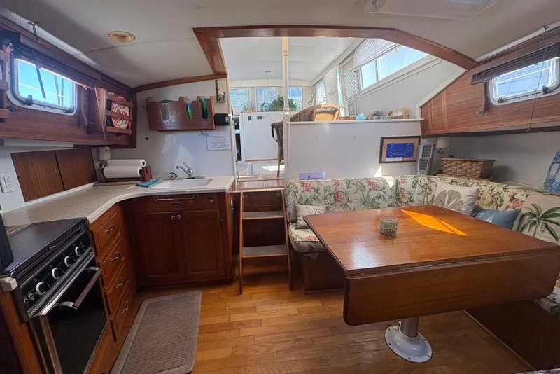 Slide: The Image of 1975 Gulfstar 43 Trawler interior with cozy dining area, wooden cabinetry, and nautical decor. - 41