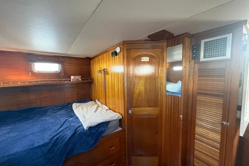 Slide: The Image of Cozy cabin interior of 1975 Gulfstar 43 Trawler with wooden paneling and bed. - 53