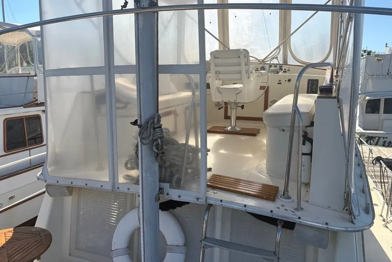 Slide: The Image of 1975 Gulfstar 43 Trawler helm with seating, enclosed bridge, and nautical equipment. - 77