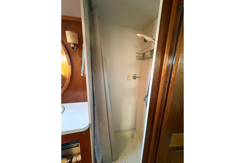 Slide: The Image of 1975 Gulfstar 43 Trawler shower area with wooden accents and compact design. - 56