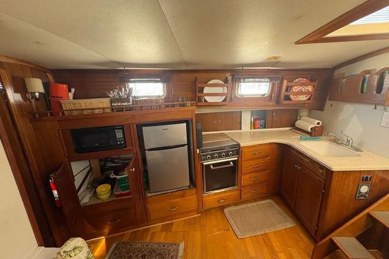 Slide: The Image of Interior of 1975 Gulfstar 43 Trawler kitchen with wooden cabinetry and modern appliances. - 37