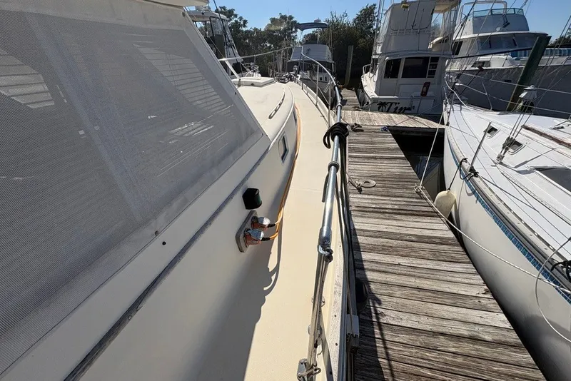 Slide: The Image of 1975 Gulfstar 43 Trawler docked, showcasing side deck and railing. - 86