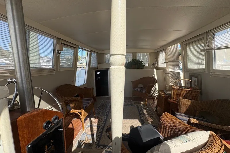 Slide: The Image of Interior of a 1975 Gulfstar 43 Trawler with wicker furniture and large windows. - 16