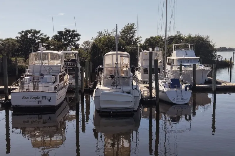 Slide: The Image of Boats docked at a marina, featuring a 1975 Gulfstar 43 Trawler. - 96