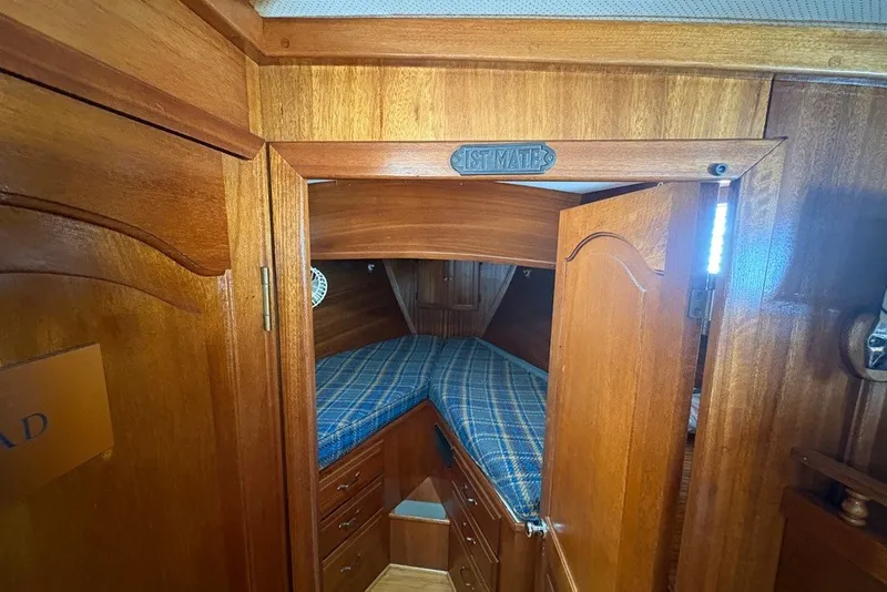 Slide: The Image of 1975 Gulfstar 43 Trawler cabin interior with wooden finish and blue plaid bedding. - 26