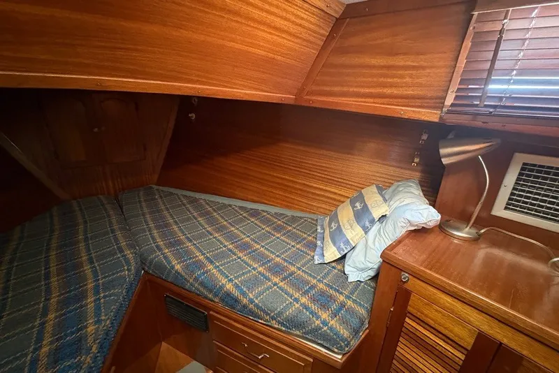 Slide: The Image of Cozy cabin interior of 1975 Gulfstar 43 Trawler with wooden finish and plaid bedding. - 32