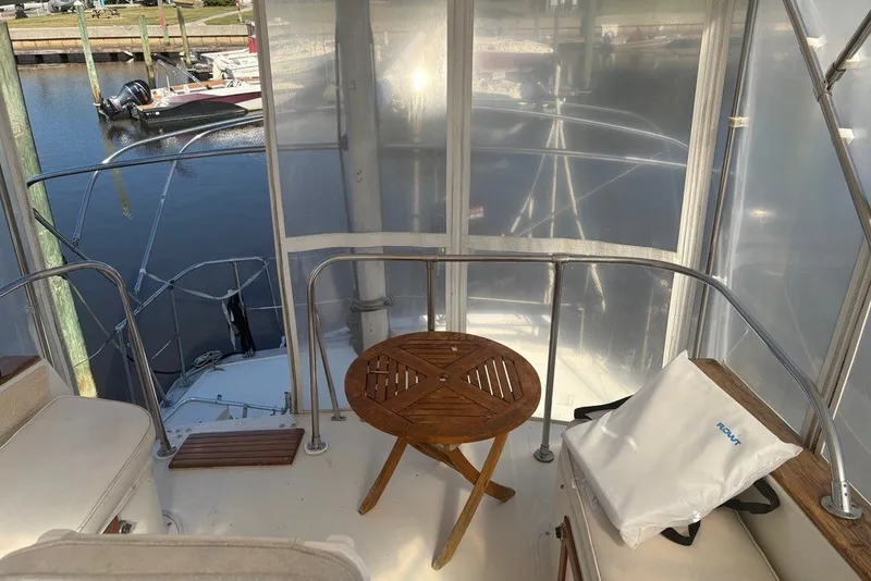 Slide: The Image of 1975 Gulfstar 43 Trawler interior with wooden table and marina view. - 74