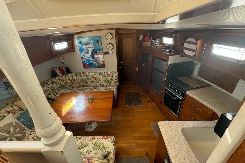 Slide: The Image of Interior of 1975 Gulfstar 43 Trawler with cozy seating, kitchen, and wooden decor. - 24