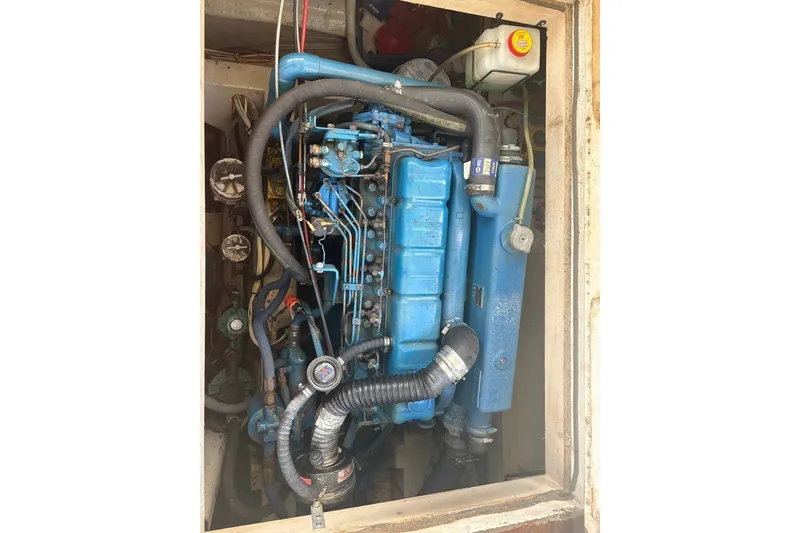 Slide: The Image of Engine compartment of a 1975 Gulfstar 43 Trawler, showcasing a blue marine engine. - 101