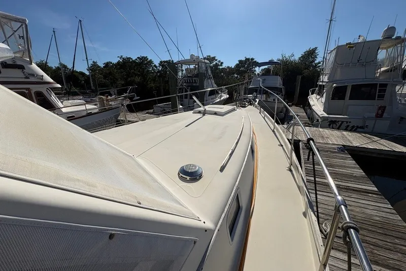 Slide: The Image of 1975 Gulfstar 43 Trawler docked at marina, surrounded by other boats under clear sky. - 87