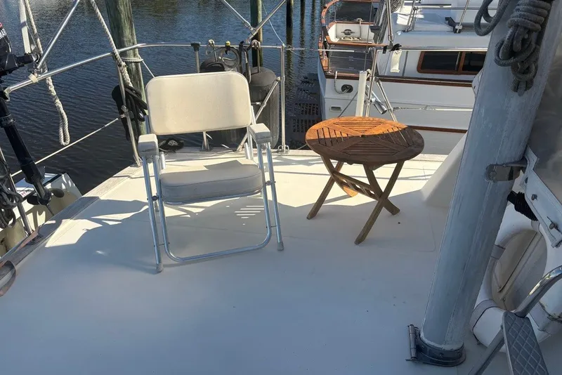 Slide: The Image of 1975 Gulfstar 43 Trawler deck with chair and wooden table by the water. - 76