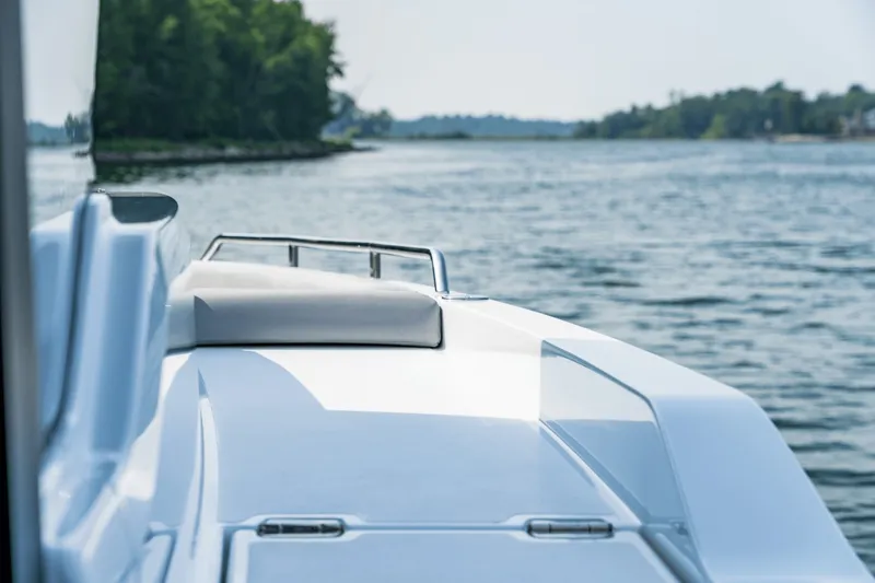 Slide: The Image of A modern boat with sleek lines cruising on calm waters near a wooded shoreline. - 19