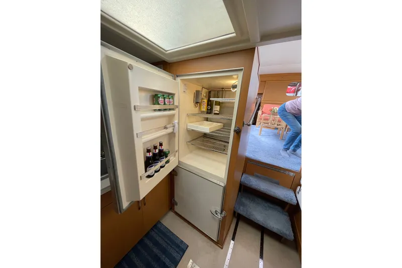 Slide: The Image of Interior of 1962 Chris-Craft 55 Commander with open fridge and visible staircase. - 20