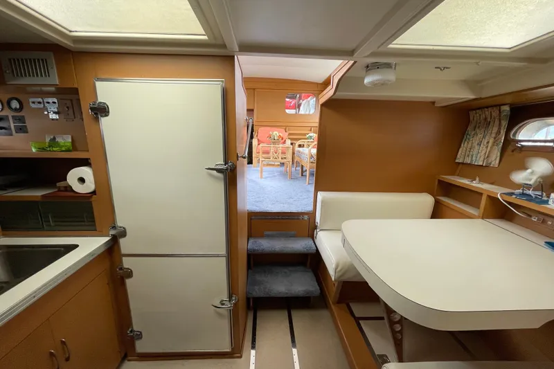 Slide: The Image of Interior of a 1962 Chris-Craft 55 Commander yacht, featuring a cozy dining area and kitchenette. - 23