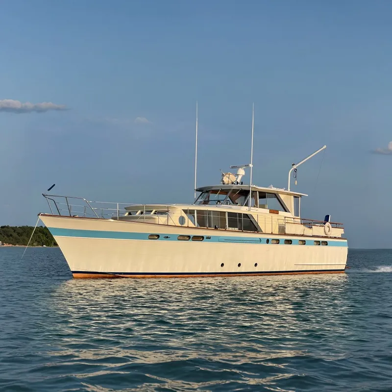 The Image of A classic 1962 Chris-Craft 55 Commander on calm waters, featuring elegant design and spacious deck. - 0