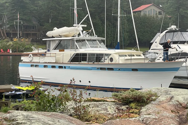 Slide: The Image of 1962 Chris-Craft 55 Commander yacht docked in a serene marina setting. - 17